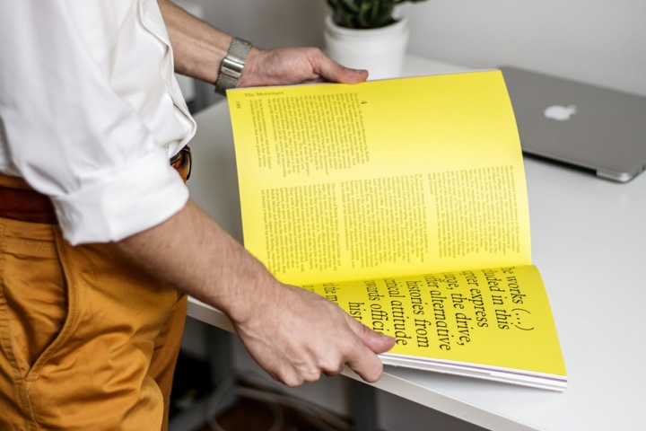 A printed yellow magazine opened on a desk